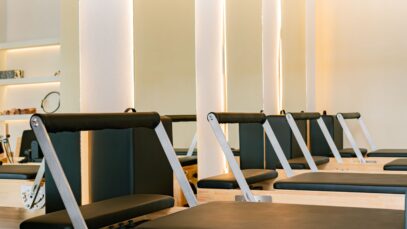 Interior of a modern Pilates studio featuring multiple reformer machines in a calming atmosphere.
