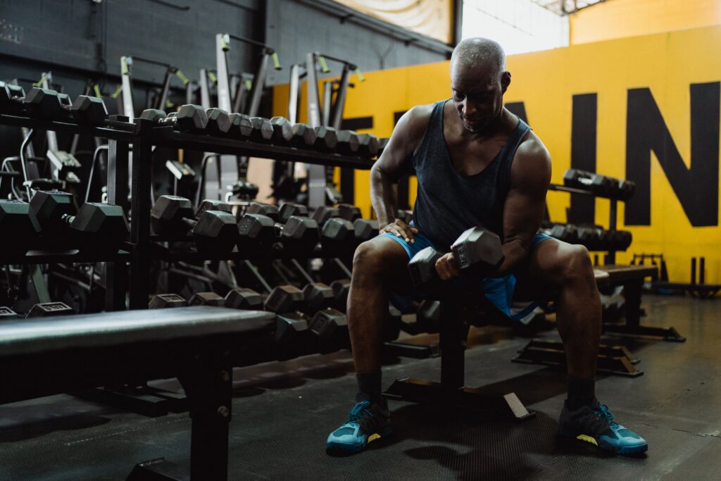 Can Drop Sets Speed Up Muscle Growth? What Trainers Need To Know 1 A muscular man lifting weights in a gym, highlighting strength and dedication.